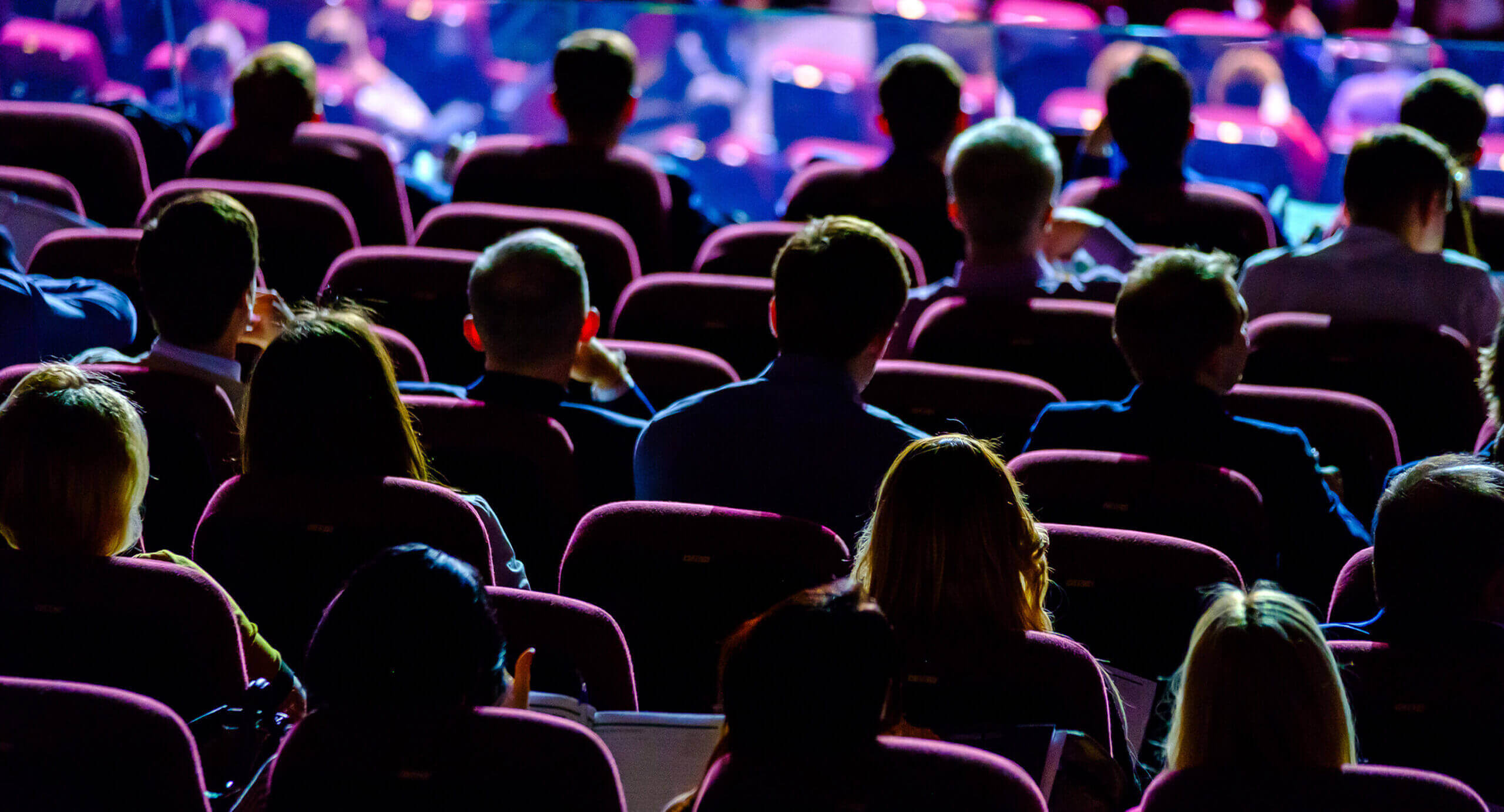 Trade show audience with multi-color lighting, used as hero background for the SwiftColor B2B campaign by Sussman Creative